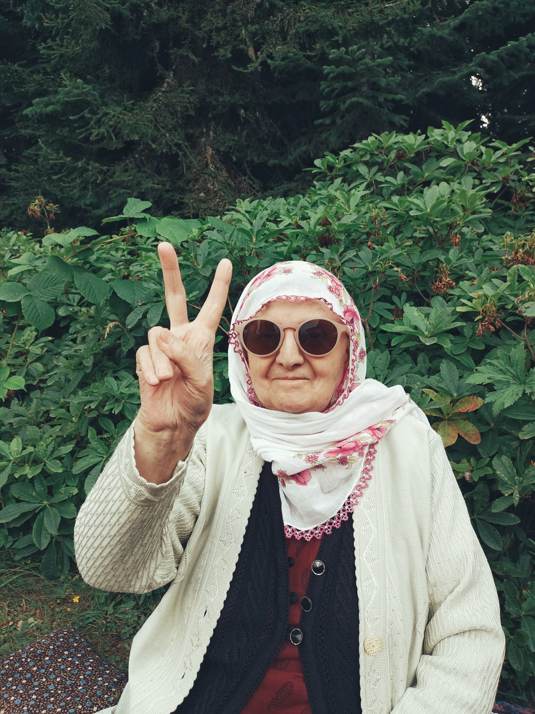 Cool old lady with sun glasses giving the peace sign